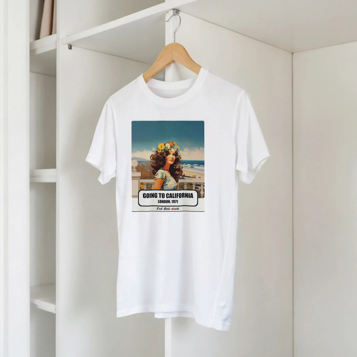 T-shirt bianca con la stampa Rock Art «Going to California – London, 1971» su una gruccia di legno, appesa a una libreria bianca