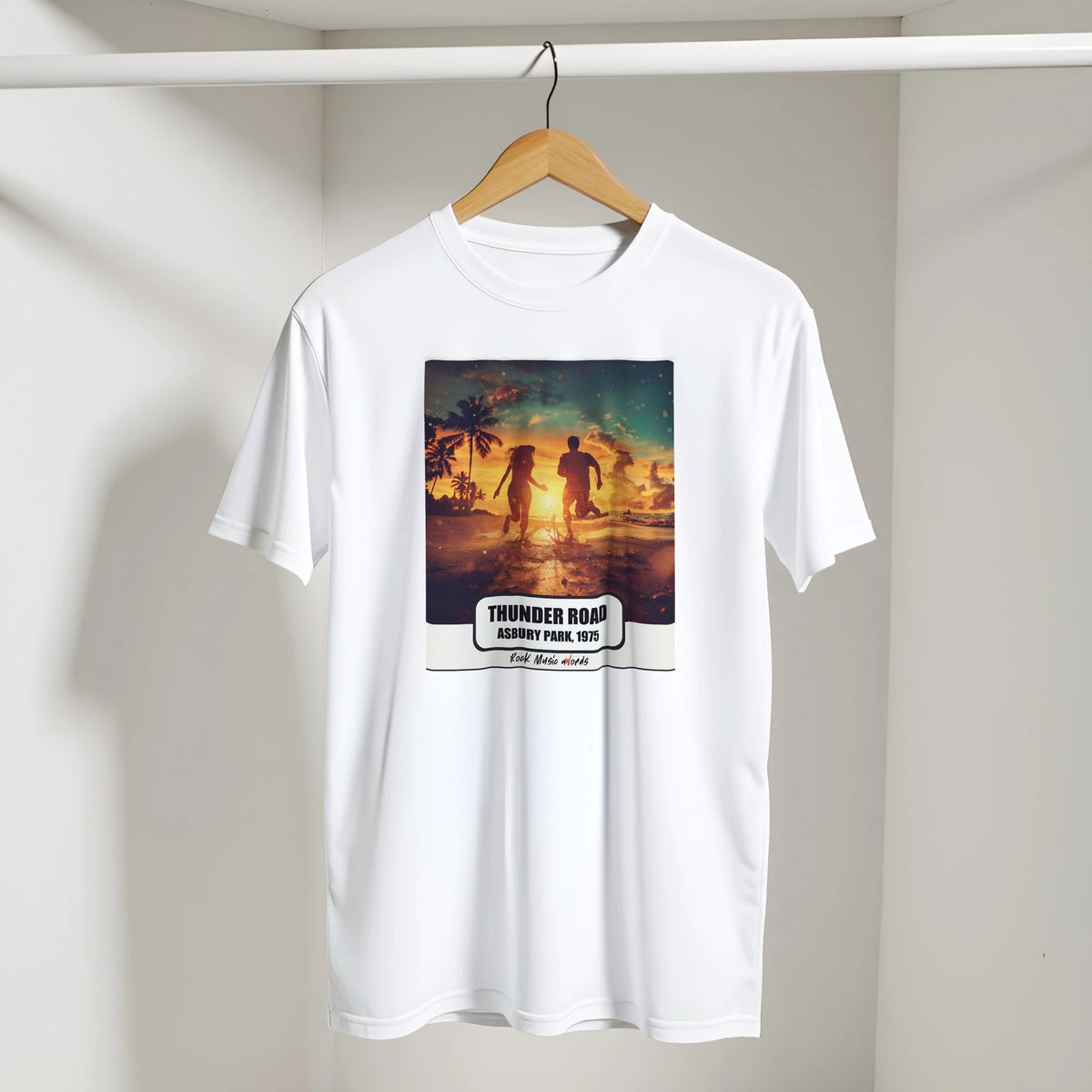 T-shirt bianca con la stampa Rock Art «Thunder Road – Asbury Park, 1975» appesa a una gruccia di legno, dentro un armadio bianco