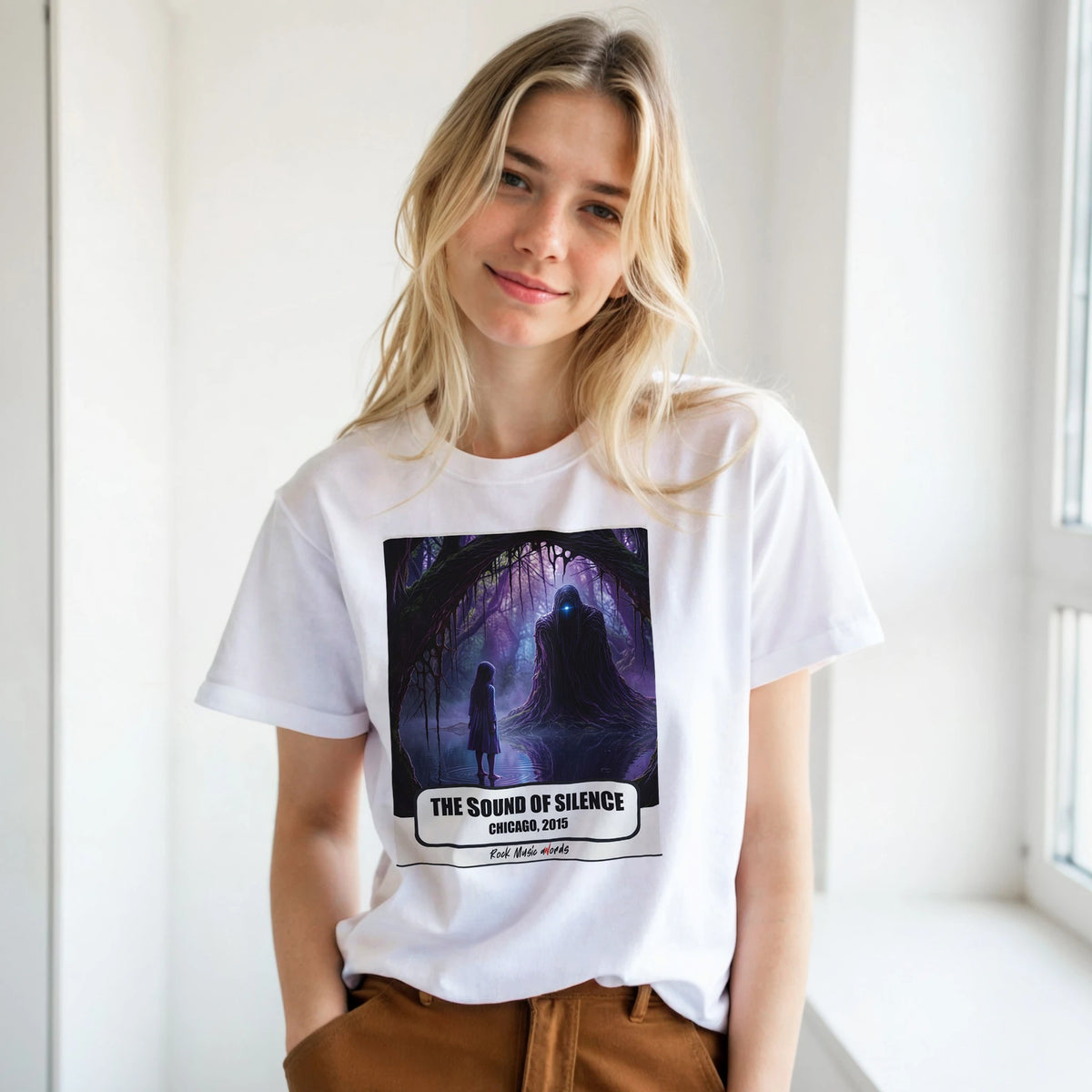 Ragazza bionda con le mani in tasca, accanto a una finestra, indossa la t-shirt bianca con la stampa Rock Art «The Sound of Silence – Chicago, 2015»