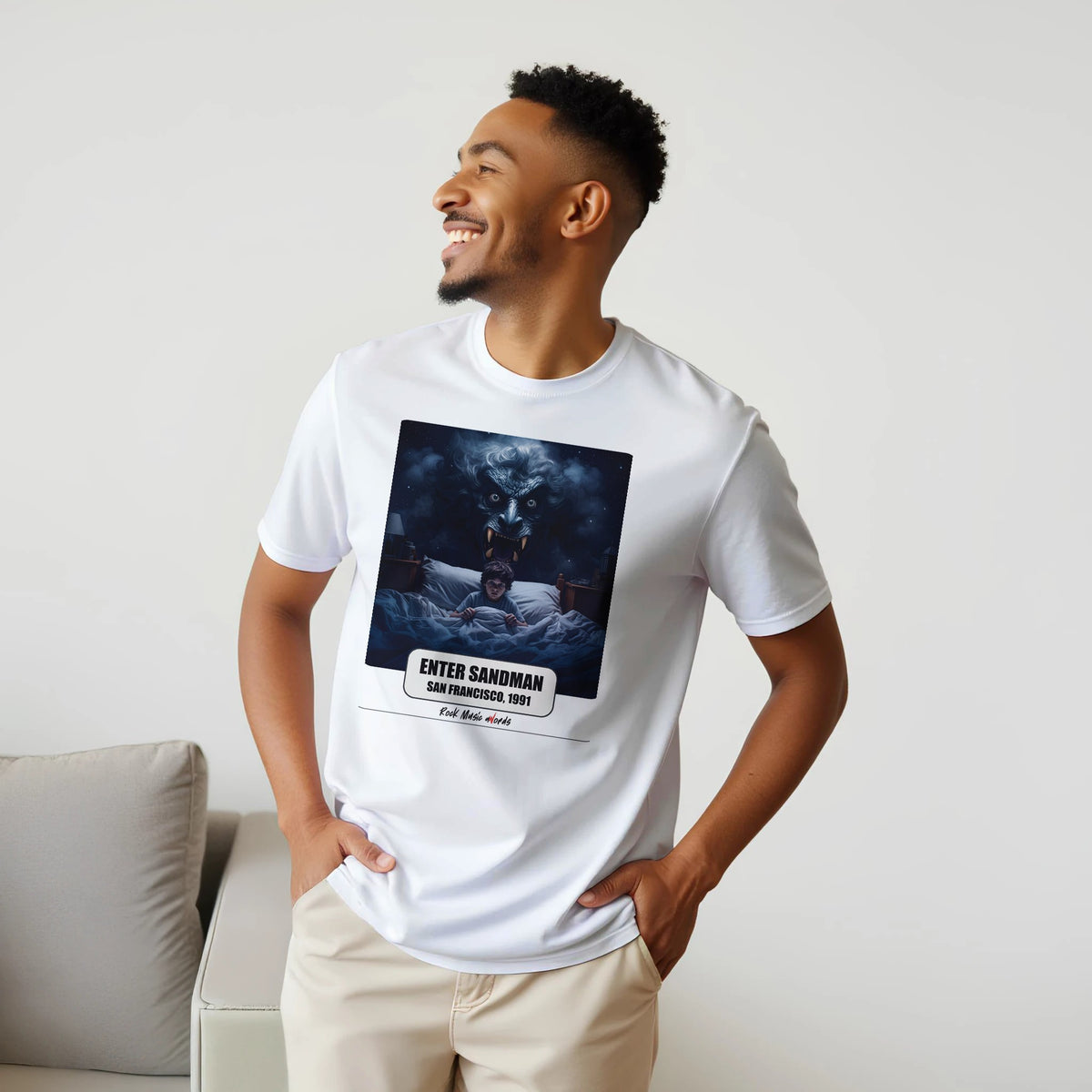 Uomo sorridente con le mani sui fianchi, accanto a un divano, indossa la t-shirt bianca con la stampa Rock Art «Enter Sandman – San Francisco, 1991»