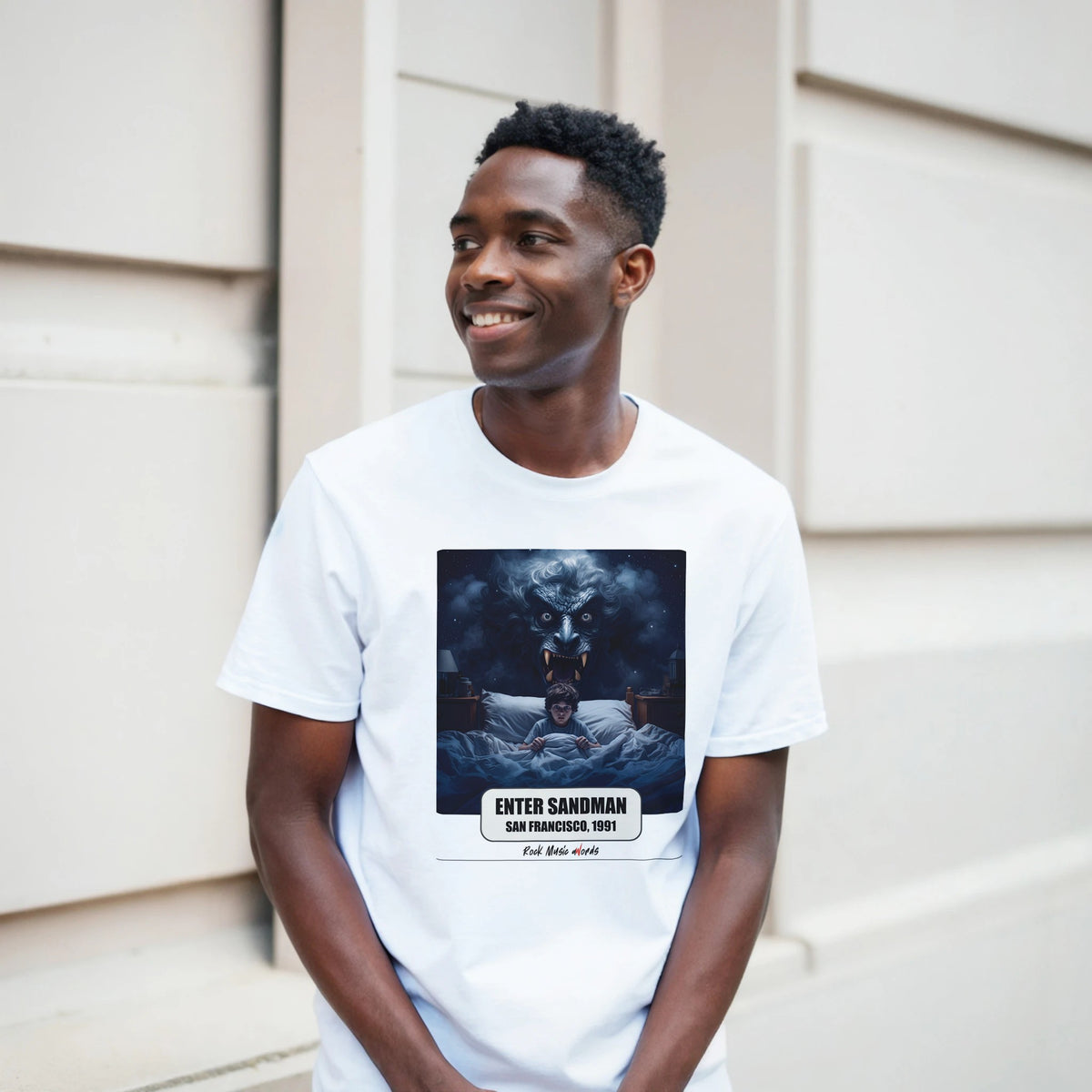 Ragazzo sorridente davanti a un muro chiaro a blocchi indossa la t-shirt bianca con la stampa Rock Art «Enter Sandman – San Francisco, 1991»