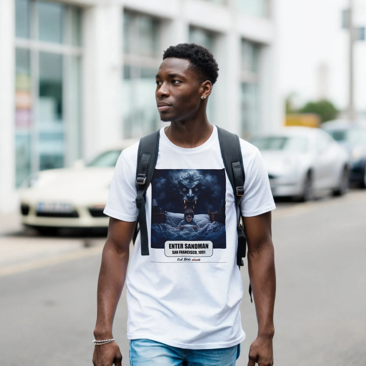 Ragazzo con zaino nero e jeans cammina per una via di città indossando la t-shirt bianca con la stampa Rock Art «Enter Sandman – San Francisco, 1991»