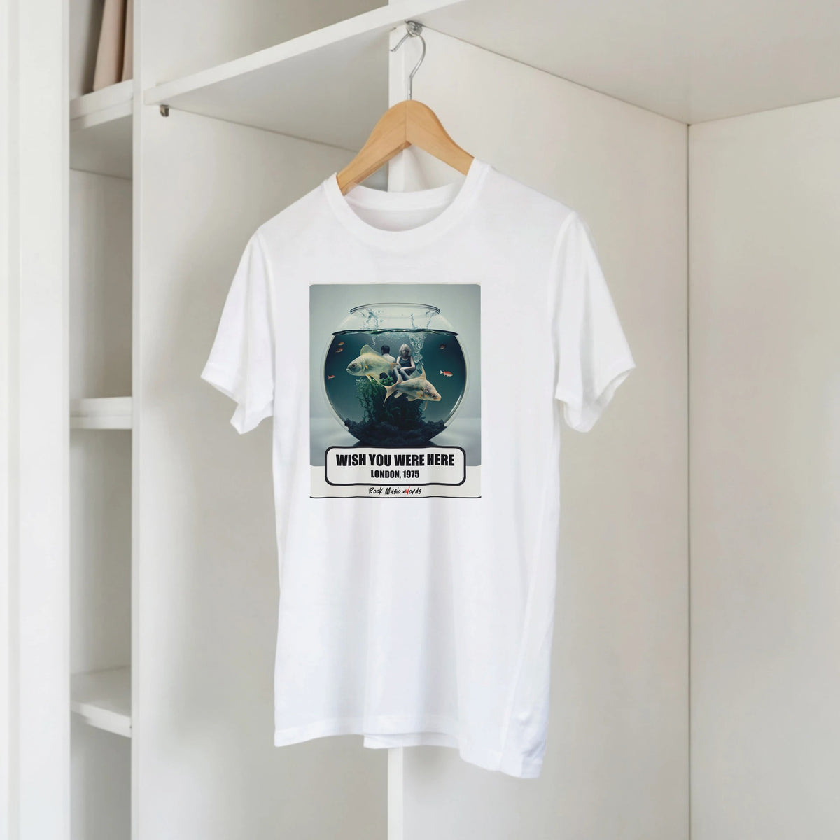 T-shirt bianca con la stampa Rock Art «Wish You Were Here – London, 1975» su una gruccia di legno, appesa a una libreria bianca