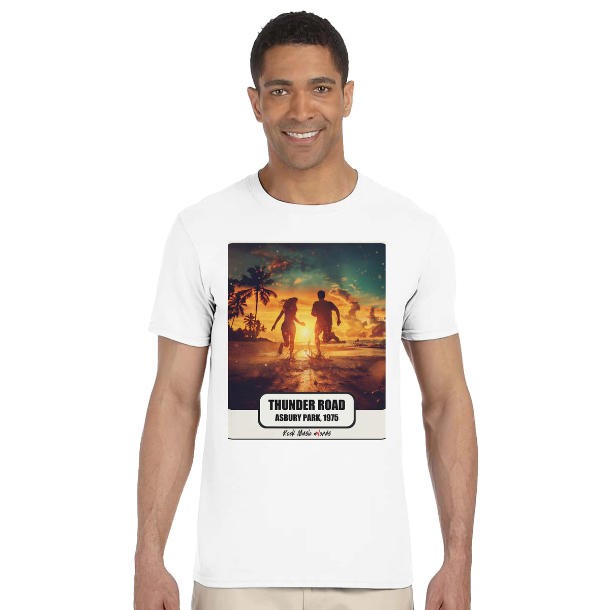 Uomo sorridente in piedi su fondo bianco indossa la t-shirt bianca con la stampa Rock Art «Thunder Road – Asbury Park, 1975»