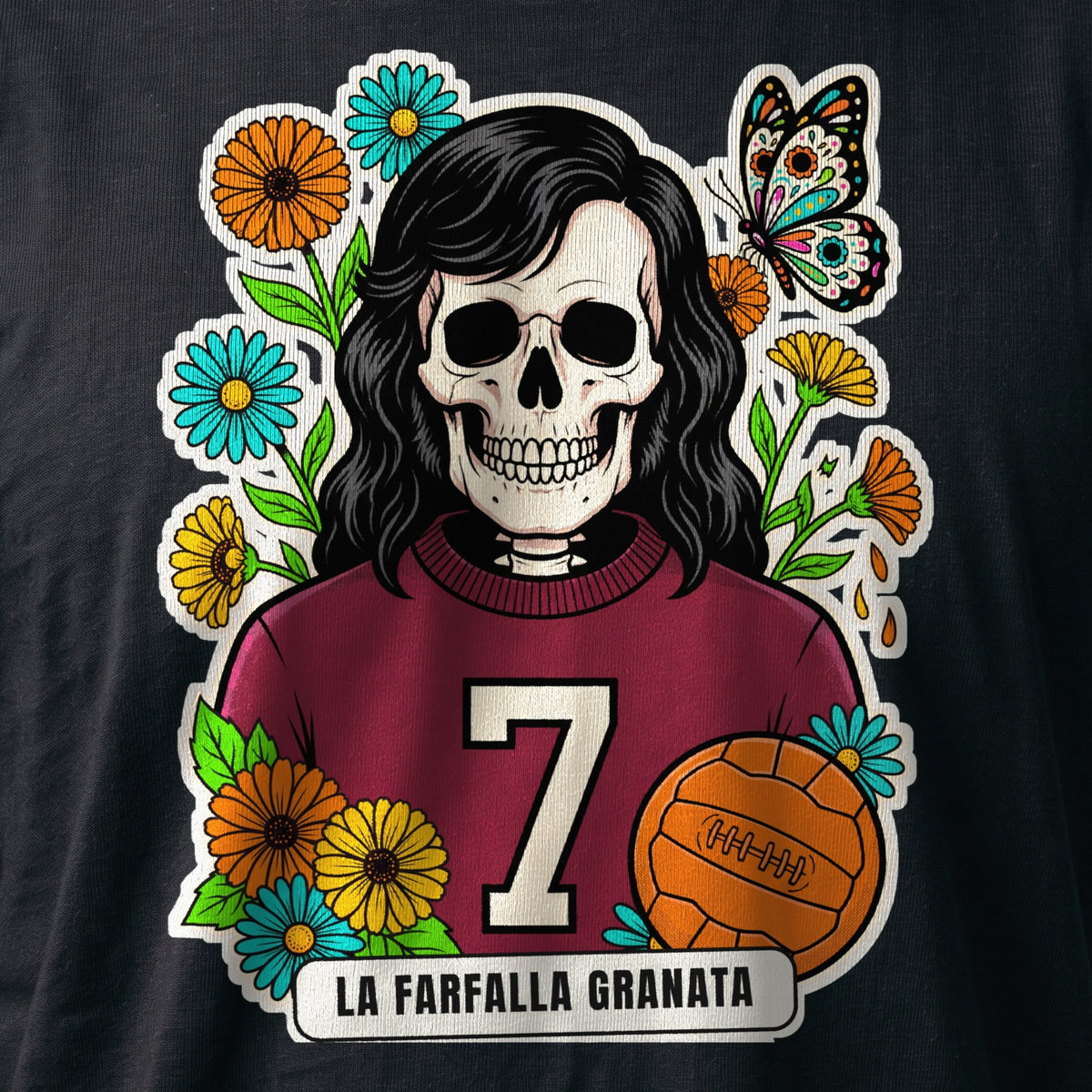 La stampa da vicino sulla t-shirt nera: la calavera La Farfalla Granata con la maglia granata numero 7, il pallone e la farfalla, sul cotone (ricostruzione al computer)