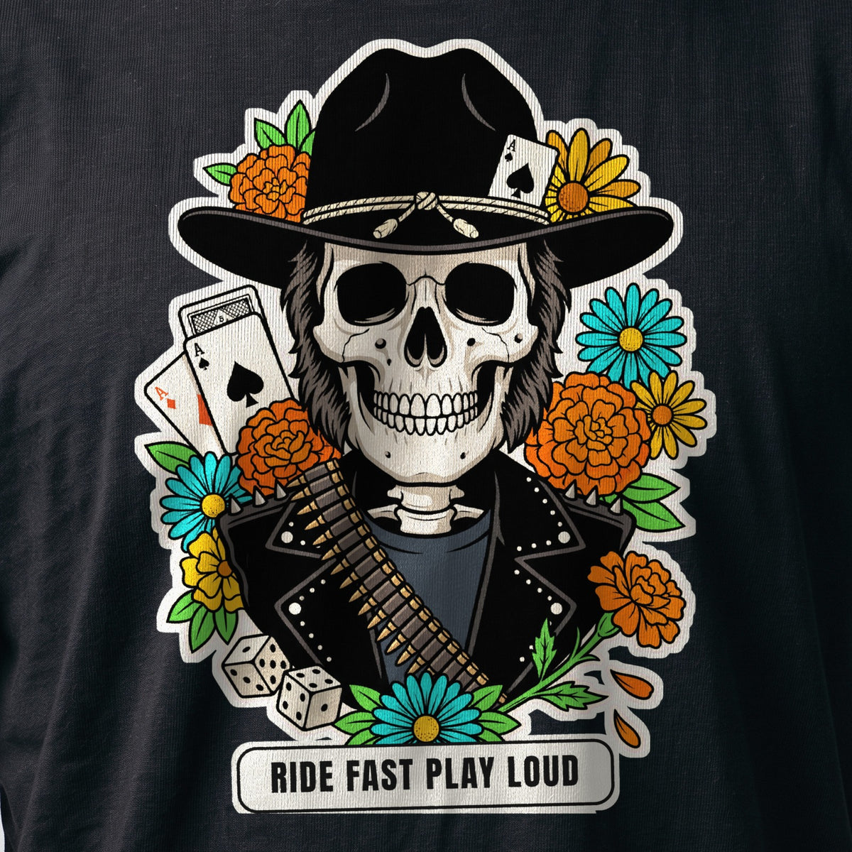 La stampa da vicino sulla t-shirt nera: la calavera Ride Fast Play Loud con il cappello nero, la cartucciera, le carte da gioco e i dadi, sul cotone (ricostruzione al computer)