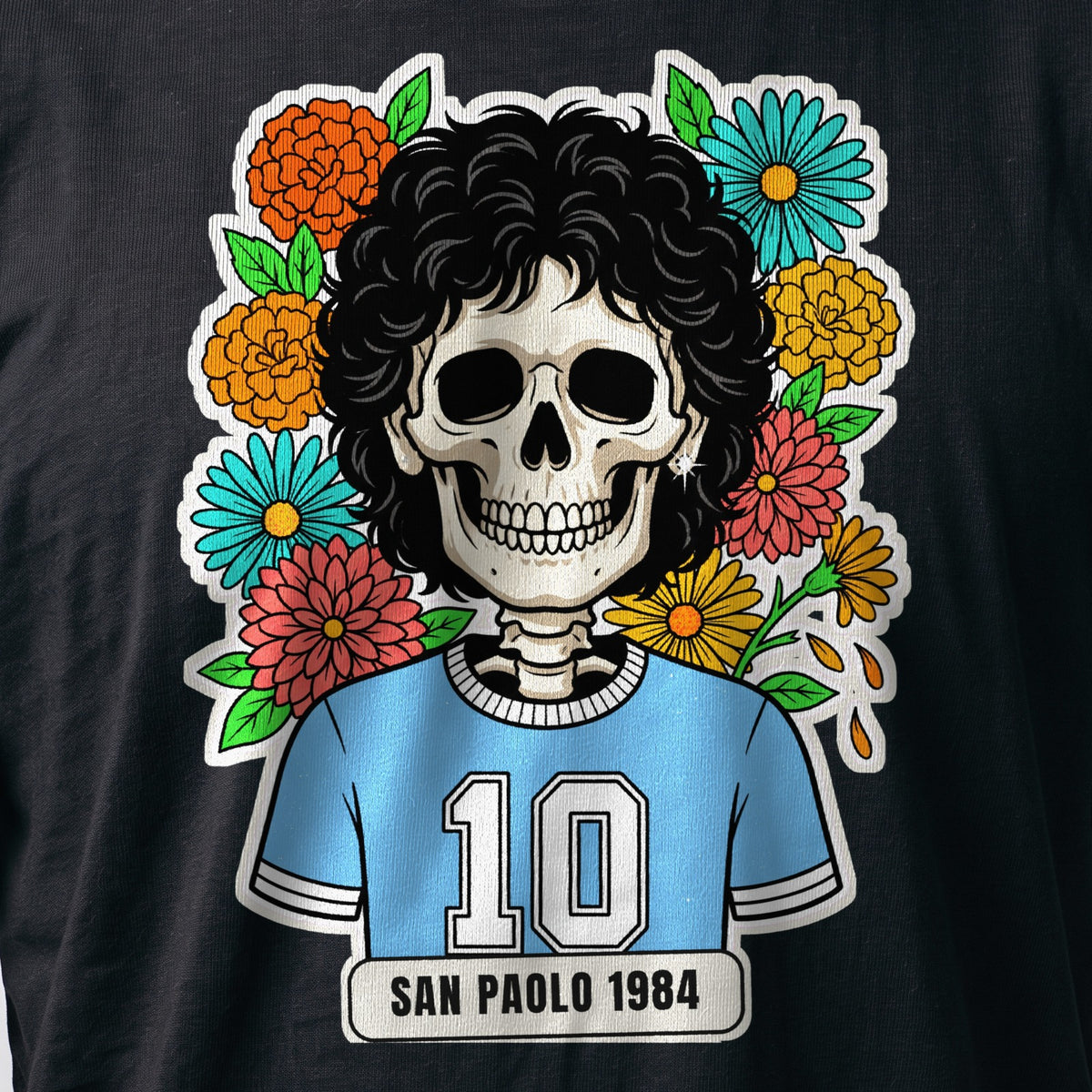 La stampa da vicino sulla t-shirt nera: la calavera San Paolo 1984 con i ricci neri e la maglia azzurra numero 10, sul cotone (ricostruzione al computer)