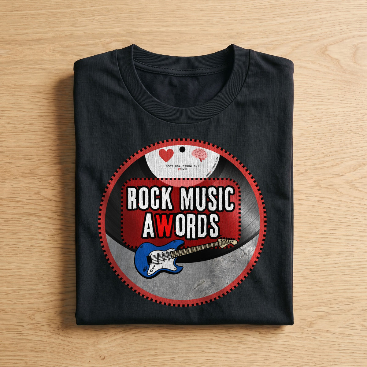 La t-shirt nera «logo Rock Music aWords tondo» piegata su un piano di legno, come arriva a casa (ricostruzione al computer)