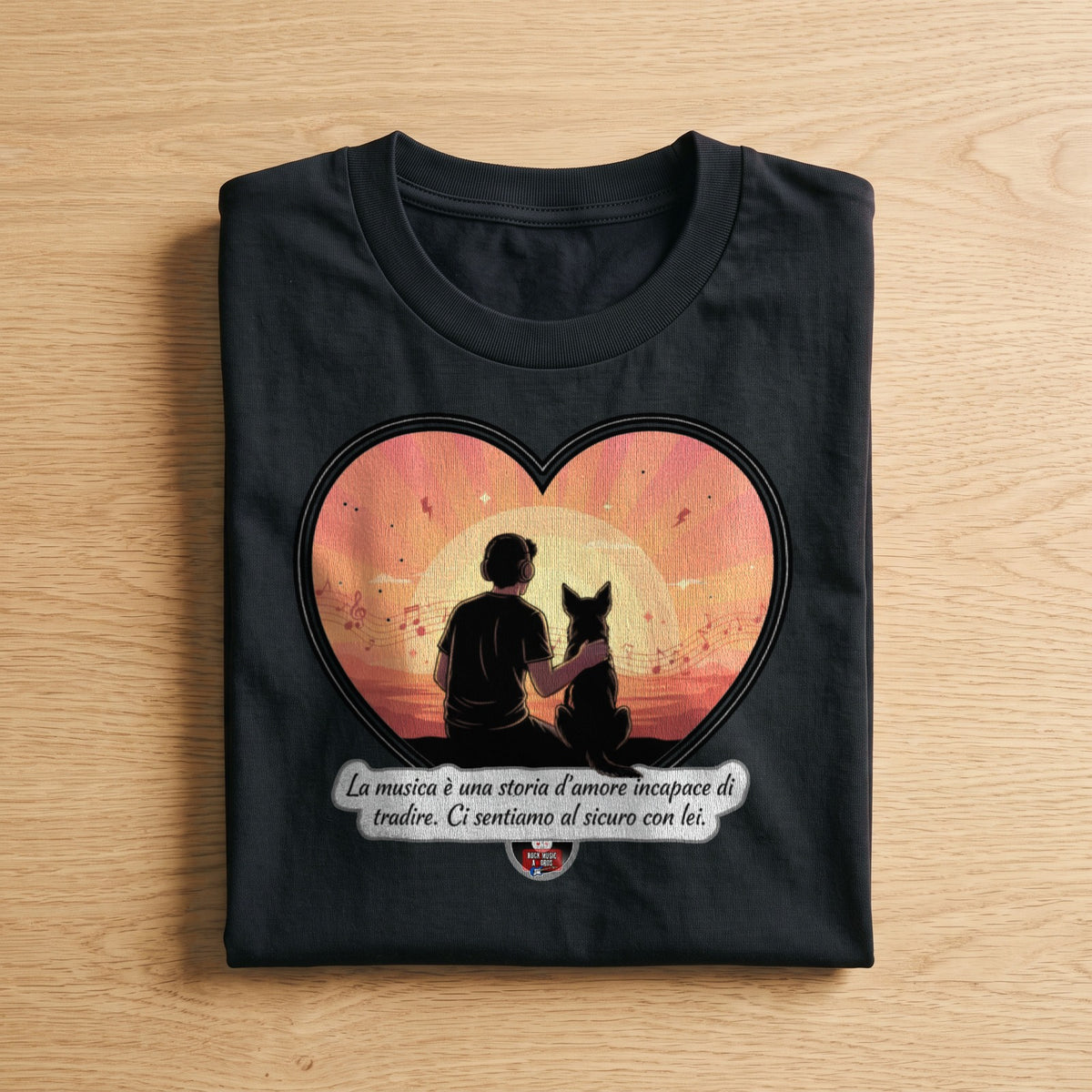 La t-shirt nera «La musica è una storia d'amore incapace di tradire» piegata su un piano di legno, come arriva a casa (ricostruzione al computer)
