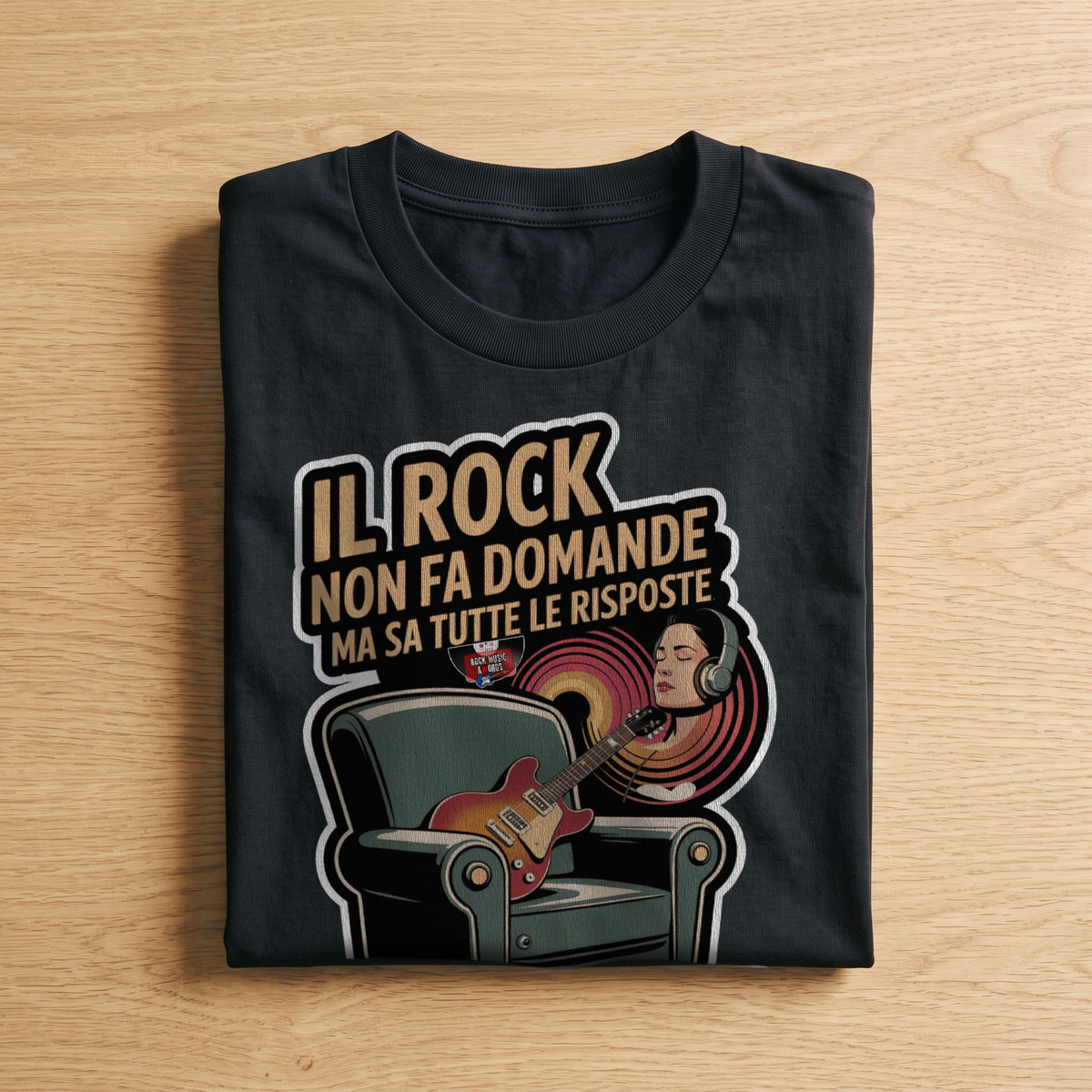 La t-shirt nera «Il rock non fa domande ma sa tutte le risposte: è la mia terapia senza appuntamento» piegata su un piano di legno, come arriva a casa (ricostruzione al computer)
